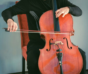 Man sitting on chair and plating cello